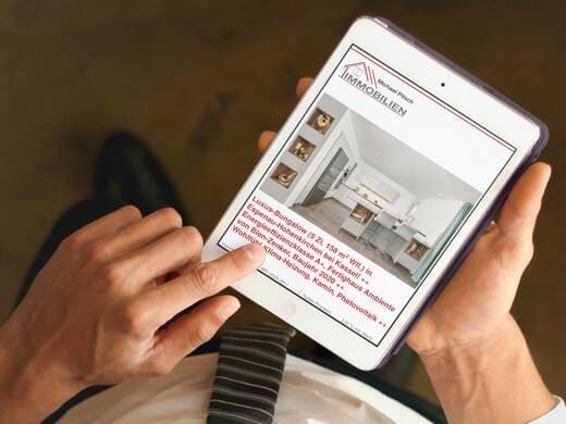 Mann in Business-Kleidung betrachtet Exposé für Luxus-Bungalow auf iPad: Verkaufsexposé mit Lage- und Objektbeschreibung.