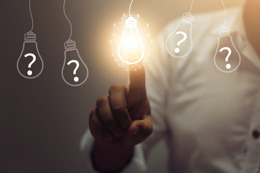 Managerin schaltet virtuelle Glühbirne an: Metapher für ihre Idee „Texte schreiben lassen vom Texter zur Kundengewinnung“.