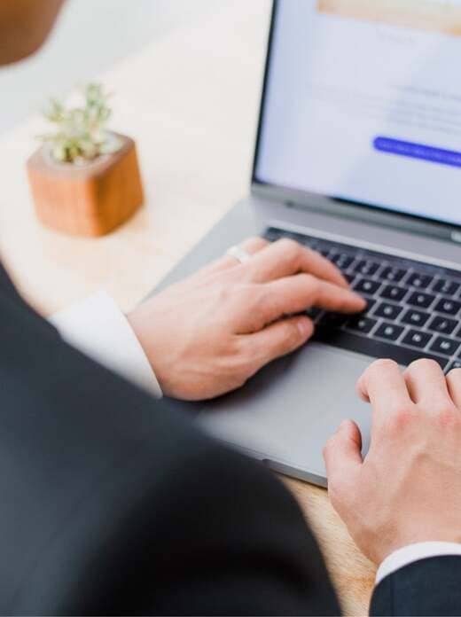 Geschäftsmann navigiert am Laptop durch Textagentur-Website: Den Texter und Content-Manager kennenlernen und Kontakt zu diesem aufnehmen möchte er!